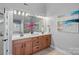 Bright bathroom features a double sink vanity with granite countertops and a large mirror at 114 Runningdeer Dr, Mooresville, NC 28117