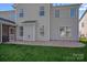 View of the home's rear exterior with brick patio, showing windows and neutral siding at 114 Runningdeer Dr, Mooresville, NC 28117