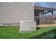 A permanently installed Generac generator on a green lawn, next to a screened porch at 114 Runningdeer Dr, Mooresville, NC 28117