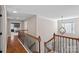 Upstairs hallway with decorative chandelier, hardwood floors, and an inviting view into the main bedroom at 114 Runningdeer Dr, Mooresville, NC 28117