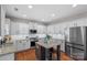 Well-lit kitchen featuring white cabinets, stainless steel appliances, granite counters, and a functional island at 114 Runningdeer Dr, Mooresville, NC 28117