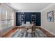 Home office featuring a bold navy accent wall, hardwood floors, and a bright window at 114 Runningdeer Dr, Mooresville, NC 28117