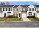 Charming exterior view of a townhouse with well-kept lawn and front yard landscaping under a blue sky at 12031 Windy Rock Way # 1002, Charlotte, NC 28273