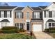 Inviting brick and siding townhome with black shutters, well-manicured landscaping and a one-car garage at 12031 Windy Rock Way # 1002, Charlotte, NC 28273