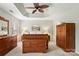 Bright main bedroom with a tray ceiling, ceiling fan, and matching wooden furniture set at 12031 Windy Rock Way # 1002, Charlotte, NC 28273