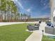 Serene backyard showcasing green grass, a white fence, and comfortable patio seating arranged around a fire pit at 12234 Rowan Hill Dr, Huntersville, NC 28078