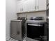 Well-equipped laundry room with modern washer and dryer, complemented by white cabinets and patterned flooring at 12234 Rowan Hill Dr, Huntersville, NC 28078