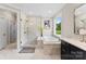 Modern bathroom featuring a glass shower, soaking tub, and dark vanity cabinets at 13108 Brooklyn Skylar Way, Huntersville, NC 28078