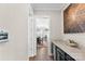 View of a hallway featuring a beverage cooler, art and entryway into a well lit dining room at 13108 Brooklyn Skylar Way, Huntersville, NC 28078