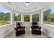 Bright sunroom with beautiful views, two leather chairs, and attractive architectural detailing at 13108 Brooklyn Skylar Way, Huntersville, NC 28078