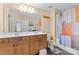 Well-lit bathroom features double sinks, wooden cabinets, and orange and white shower curtain at 14139 Winford Ln, Charlotte, NC 28262