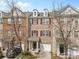 Charming brick townhome featuring a one-car garage and dormer windows under a beautiful blue sky at 14139 Winford Ln, Charlotte, NC 28262