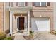 Inviting townhome entrance with a covered porch, attached one-car garage and beautiful landscaping at 14139 Winford Ln, Charlotte, NC 28262