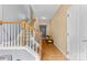 Sunlit hallway with hardwood floors, staircase, and a view into the rest of this beautiful home at 14139 Winford Ln, Charlotte, NC 28262