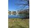 Scenic pond with a fountain and surrounding trees reflects the clear blue sky and nearby houses at 14139 Winford Ln, Charlotte, NC 28262