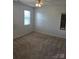 This bedroom includes carpet, a window with natural light, and neutral colored walls at 14922 Rolling Sky Dr, Charlotte, NC 28273