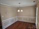 Dining room with chair rail molding, hardwood floors, and chandelier with bright natural lighting at 14922 Rolling Sky Dr, Charlotte, NC 28273