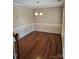 Dining room with hardwood floors, chandelier, chair rail molding, and bright natural lighting at 14922 Rolling Sky Dr, Charlotte, NC 28273