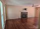 Cozy living room featuring a stone fireplace, ceiling fan, and hardwood floors at 14922 Rolling Sky Dr, Charlotte, NC 28273