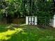 Backyard shed, ideal for extra storage, nestled among mature trees and a partial wooden fence at 14922 Rolling Sky Dr, Charlotte, NC 28273