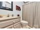 Bathroom featuring a vanity with cream colored sink and a toilet near a striped shower curtain at 1531 Wheaton Nw Way, Concord, NC 28027