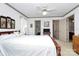 Bedroom showcasing a wooden-frame bed, ceiling fan, neutral walls and access to the bathroom at 1531 Wheaton Nw Way, Concord, NC 28027