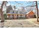 Classic brick home featuring dormer windows, a charming front porch, and a well-manicured lawn at 1531 Wheaton Nw Way, Concord, NC 28027