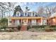 Classic brick home featuring dormer windows and a welcoming front porch, complemented by well-maintained landscaping at 1531 Wheaton Nw Way, Concord, NC 28027