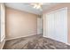 Neutral bedroom with carpeting, ceiling fan and white closet doors at 17847 Caldwell Track Dr, Cornelius, NC 28031