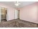 Pink bedroom featuring walk-in closet with shelving and ceiling fan at 17847 Caldwell Track Dr, Cornelius, NC 28031