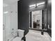 Modern bathroom featuring tiled shower, vanity, and dark wallpaper at 18334 Dembridge Dr, Davidson, NC 28036