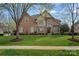 Charming brick home featuring mature trees and expansive grassy front yard at 18334 Dembridge Dr, Davidson, NC 28036