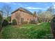 Rear exterior view of a brick home featuring a well-maintained lawn and mature trees at 18334 Dembridge Dr, Davidson, NC 28036