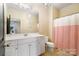 Bright bathroom with red striped shower curtain, white cabinets and large mirror at 1838 Landry Ln, Rock Hill, SC 29732