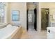 Bright bathroom with soaking tub, open doorway to closet, and a walk in shower at 1838 Landry Ln, Rock Hill, SC 29732