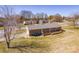 Aerial view of a brick home with a well-maintained lawn, a wooden deck, and mature trees in the neighborhood at 19 Harolds Ct, Taylorsville, NC 28681