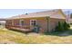 View of the brick home's backyard featuring a wooden deck and sliding glass doors at 19 Harolds Ct, Taylorsville, NC 28681