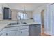 A kitchen with stainless steel dishwasher and double basin sink under a window with a chandelier at 19 Harolds Ct, Taylorsville, NC 28681