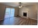 Cozy living room featuring a fireplace, wood-look floors, a ceiling fan and a sliding glass door to the deck at 19 Harolds Ct, Taylorsville, NC 28681