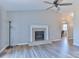 Open living room with a fireplace, light wood floors and large ceiling fan at 19 Harolds Ct, Taylorsville, NC 28681