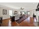 Bright living room featuring hardwood floors, ceiling fan, and a traditional fireplace with an archway leading to the sunroom at 2018 Links View Dr, Fort Mill, SC 29707