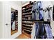 Organized walk-in closet featuring built-in shelves for shoe storage, complemented by hanging clothes and a full-length mirror at 2018 Links View Dr, Fort Mill, SC 29707