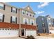 Lovely two-story townhome boasts a mix of brick and siding with black shutters and pristine white garage door at 2175 Autumn Cyprus Ave, Gastonia, NC 28054