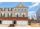 Charming three-story townhome features a brick facade, two-car garage, and inviting front entrance at 2175 Autumn Cyprus Ave, Gastonia, NC 28054