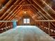 Unfinished attic space with exposed beams, offering potential for customization and additional storage at 2411 Calais Pl, Charlotte, NC 28211