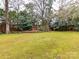 Large, well-maintained backyard lush green lawn, and mature trees create a serene outdoor space at 2411 Calais Pl, Charlotte, NC 28211