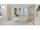 Luxurious bathroom with jacuzzi tub, walk-in shower, and plenty of natural light at 2411 Calais Pl, Charlotte, NC 28211