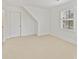 Bright, carpeted bedroom featuring a shuttered window and walk-in closet at 2411 Calais Pl, Charlotte, NC 28211