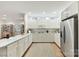 Bright eat-in kitchen features white cabinetry, stainless steel appliances, and hardwood floors at 2411 Calais Pl, Charlotte, NC 28211
