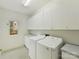 Functional laundry room with washer, dryer, and ample cabinet space at 2411 Calais Pl, Charlotte, NC 28211